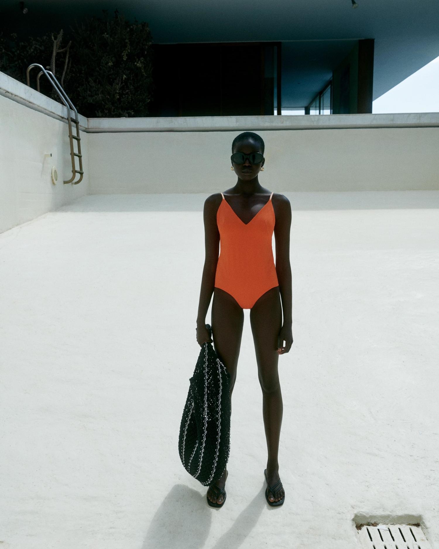 Ajok Madel by Robin Galiegue for COS Summer 2021 Ad Campaign. Clothing & Accessories: COS ORANGE DRAWSTRING SWIMSUIT / COS BLACK CROCHET SHOPPER BAG / COS BLACK LEATHER FLIP FLOPS