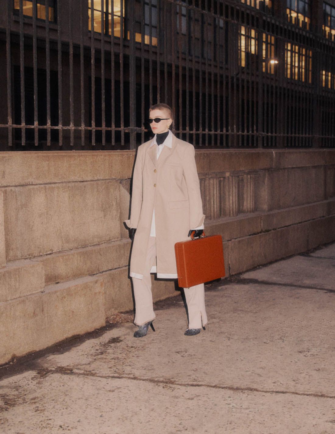 Clothing & Accessories: COMMISSION Beige Pleated wool-twill straight-leg pants / Coat, Shirt by Commission; Boots, Earrings by Balenciaga; Sunglasses by Andy Wolf. Photographer: Nagi Sakai. Stylist: Natasha Royt. Hair Stylist: Pasquale Ferrante. Makeup Artist: Ingeborg