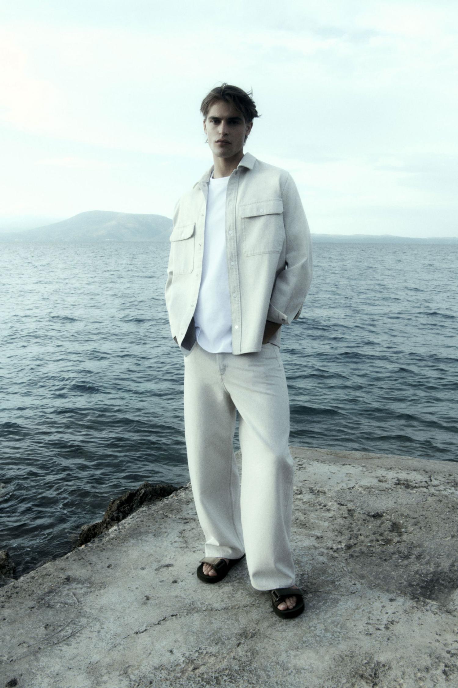 Parker Van Noord by Robin Galiegue for COS Summer 2021 Ad Campaign  Clothing & Accessories: COS OFF-WHITE RELAXED WIDE-LEG JEANS / COS WHITE REGULAR-FIT LONG-SLEEVE T-SHIRT / COS BLACK STRAP SANDALS / Photographer: Robin Galiegue. Stylist: Virginie Benarroch. Hair Stylist: Michal Bielecki. Makeup Artist: Siddhartha Simone. Art Director: Andy Knappett