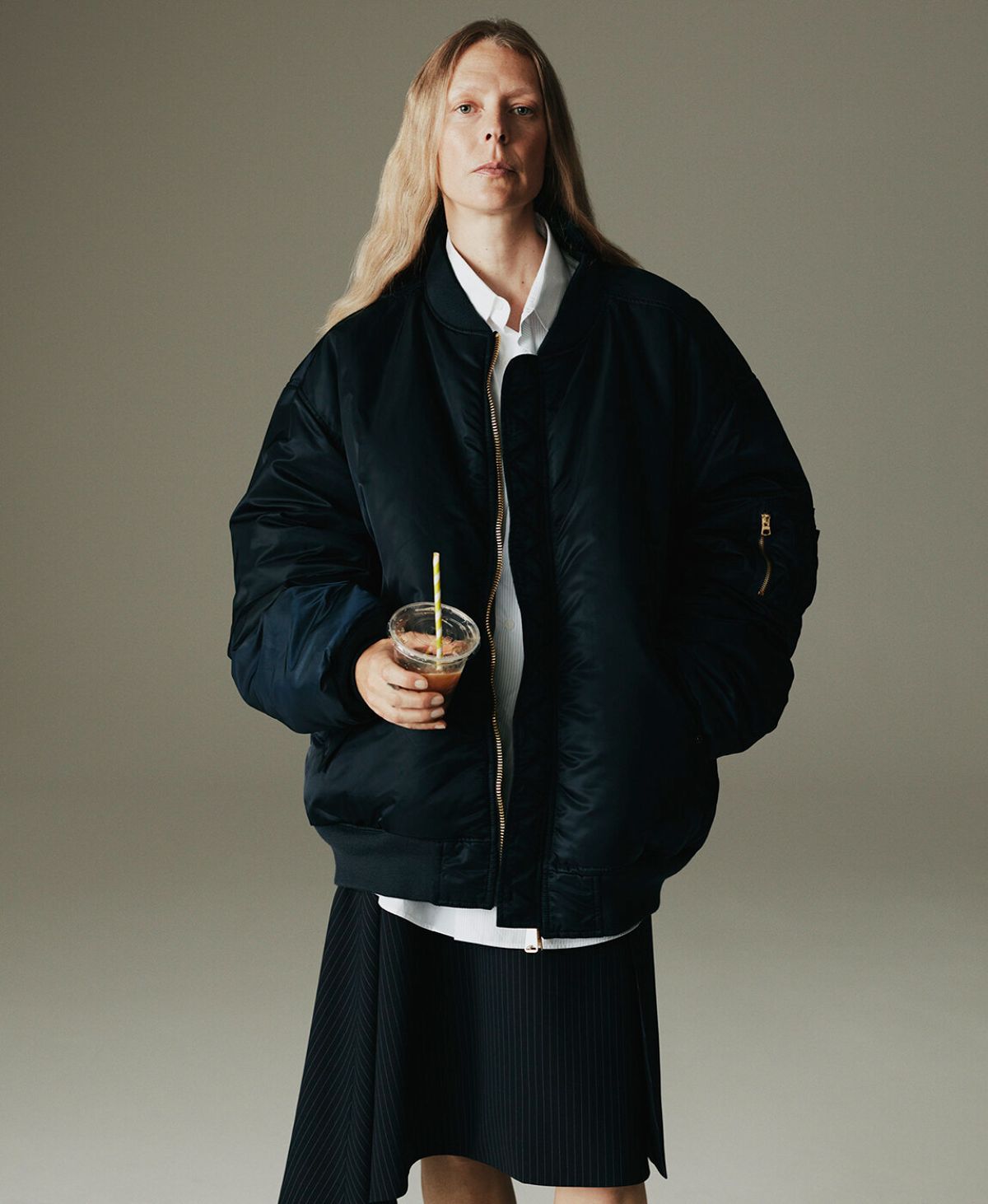 Clothing & Accessories: Vetements Navy Reversible oversized padded bomber jacket / The Frankie Shop White Lui organic cotton-poplin shirt / Vetements Navy Asymmetric pinstripe wool-blend skirt Hybrid Dressing: Laura Morgan by Sarah Piantadosi for Matches Fashion Fall-Winter 2021 Ad Campaign