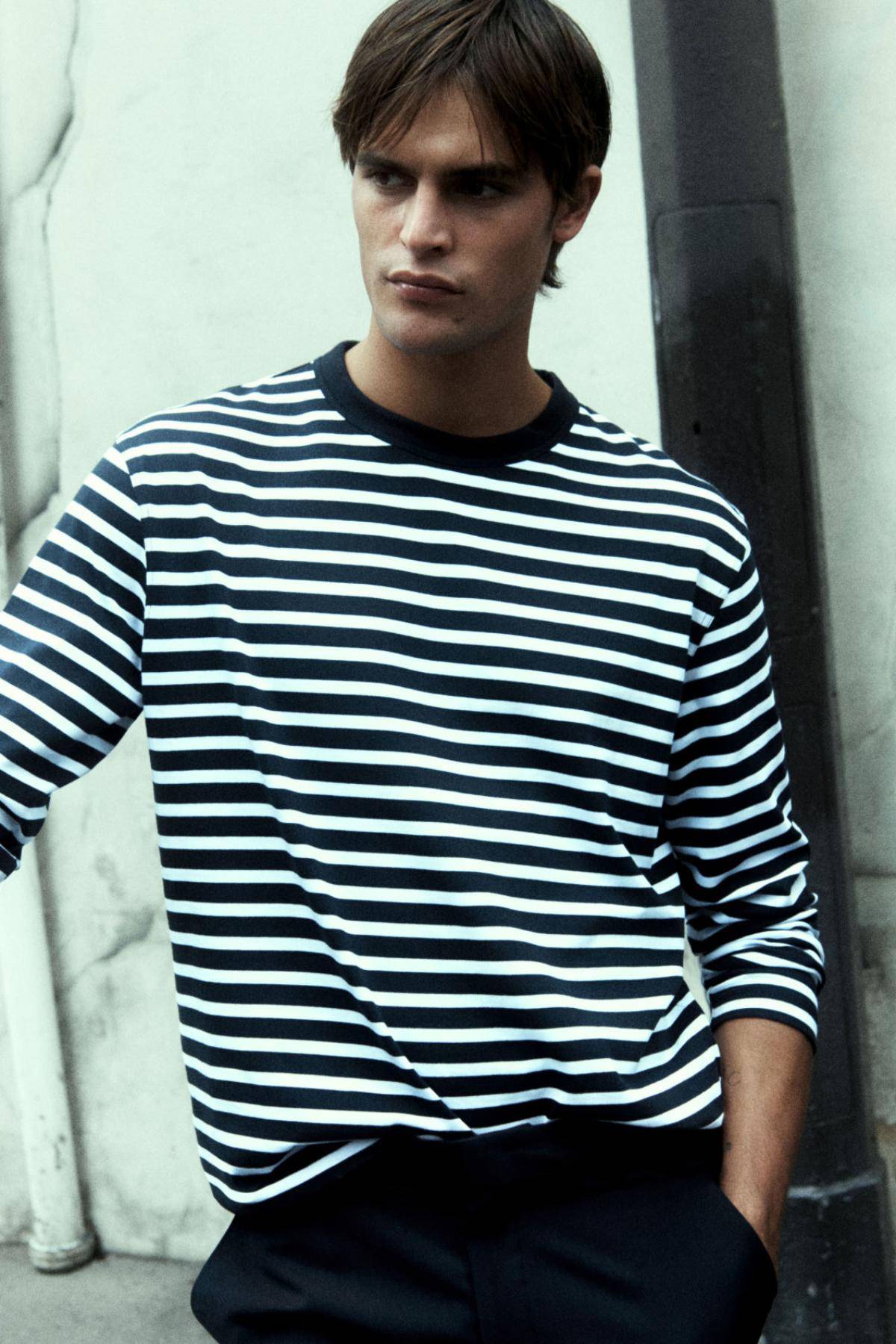 Clothing: COS NAVY-WHITE RELAXED-FIT LONG-SLEEVE T-SHIRT / COS NAVY RELAXED-FIT TAPERED CHINOS / Model: Parker Van Noord. Photographer: Robin Galiegue. Stylist: Virginie Benarroch. Hair Stylist: Michal Bielecki. Makeup Artist: Mayumi Oda. Art Director: Andy Knappett