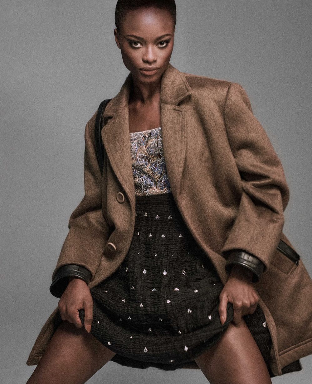 Express Lane: Mayowa Nicholas by Chris Colls for Elle Magazine September 2021. Clothing & Accessories: Coat, dress by Louis Vuitton; Shoulder bag by Louis Vuitton x Fornasetti