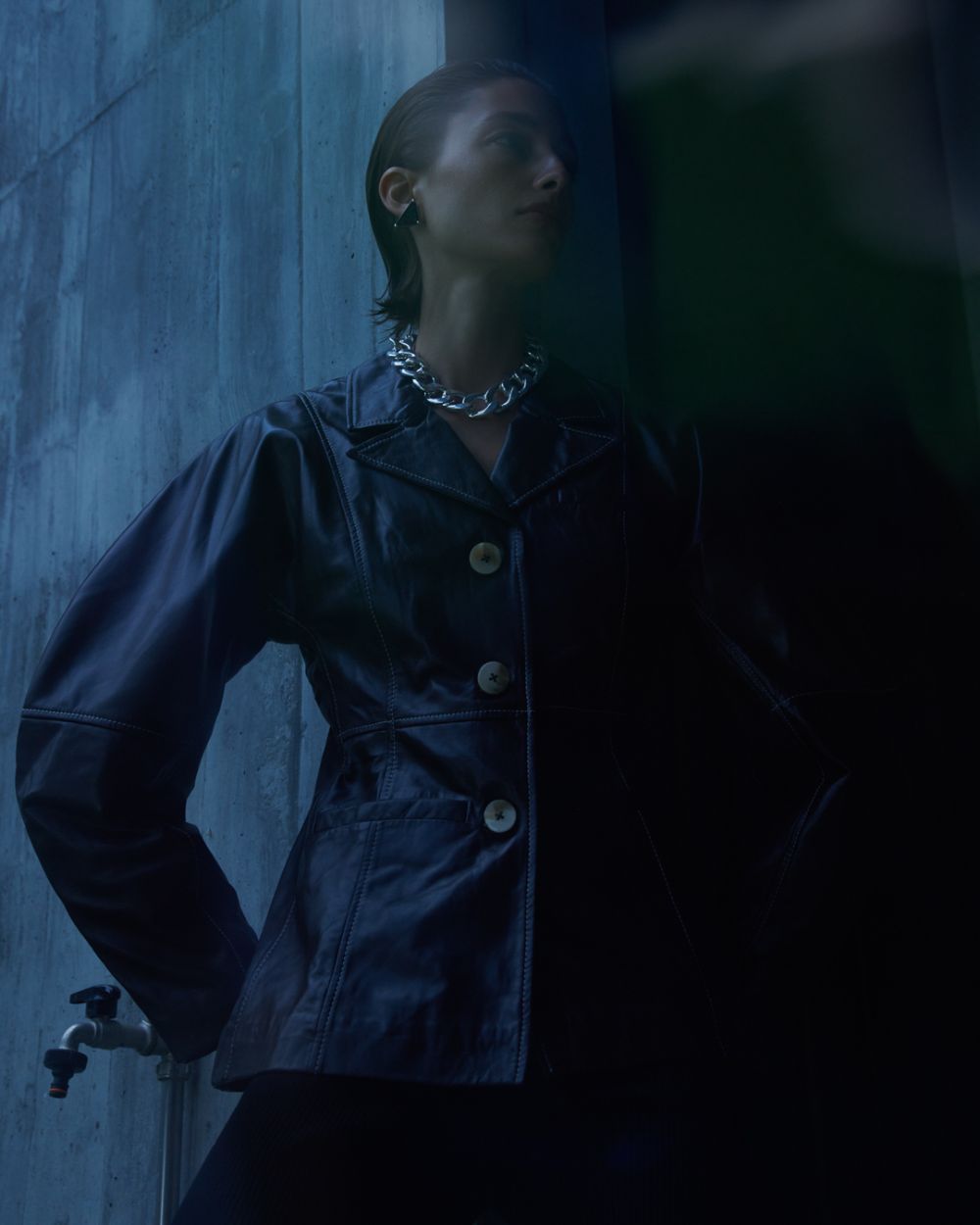  Clothing & Accessories: Leather blazer by Ganni / Triangle sterling silver single clip earring by Prada / Sterling silver-plated brass curb chain choker-style necklace by Saskia Diez / Photographer: Andreas Ortner. Stylist: Elke Dostal. Beauty Artist: Sarah Rabel 
