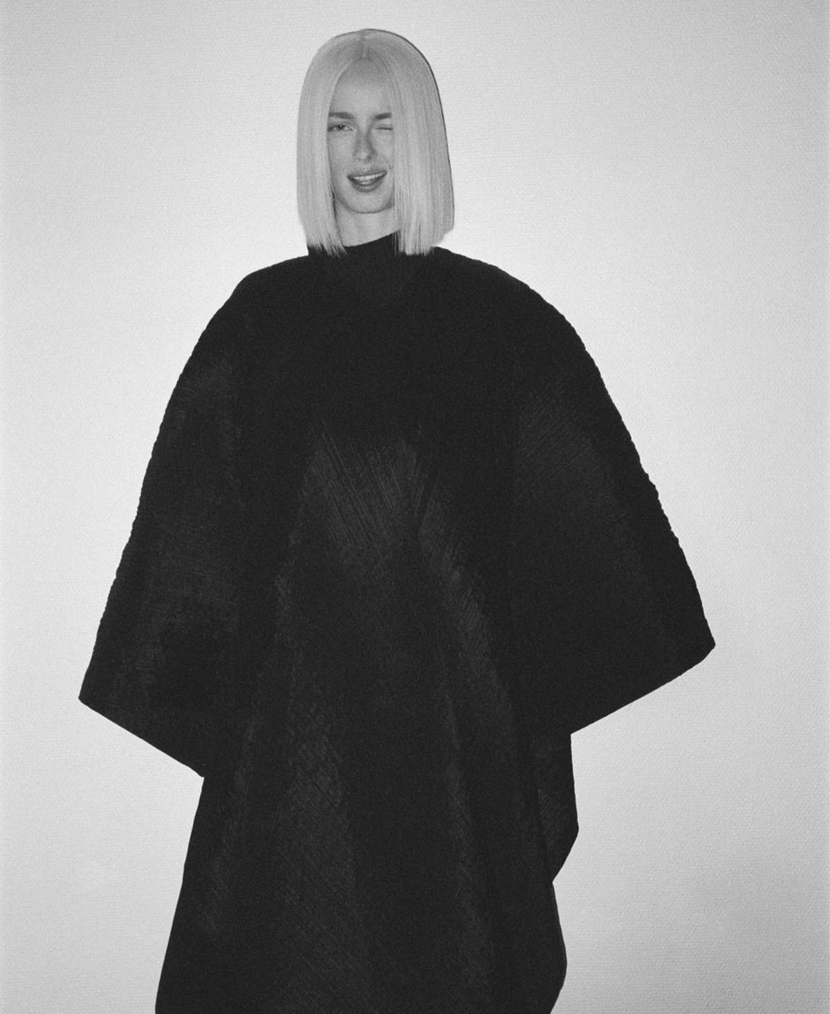 Clothing: Pleated polyester cape by Pleats Please Issey Miyake. Model: Rianne van Rompaey. Photographer: Henrik Purienne. Hair Stylist: Damien Boissinot. Makeup Artist: Christelle Cocquet