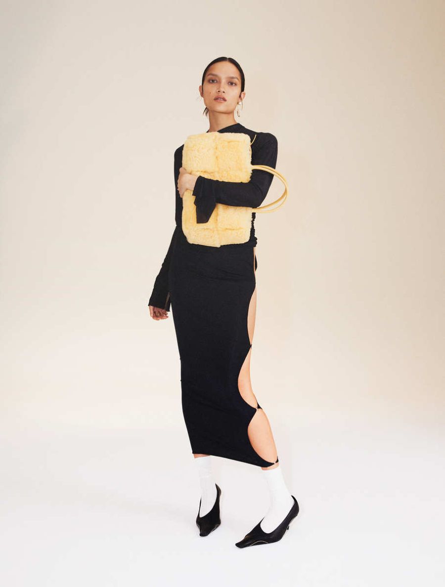 Charlotte Carey by Mattias Bjorklund for Elle Sweden January 2022 Clothing & Accessories: Top and skirt, both by Jade Cropper / Socks by COS / The Arco Yellow small leather and shearling tote bag by Bottega Veneta / Black Pointed Bavotte Heels by Acne Studios / Earrings by Christian Dior
