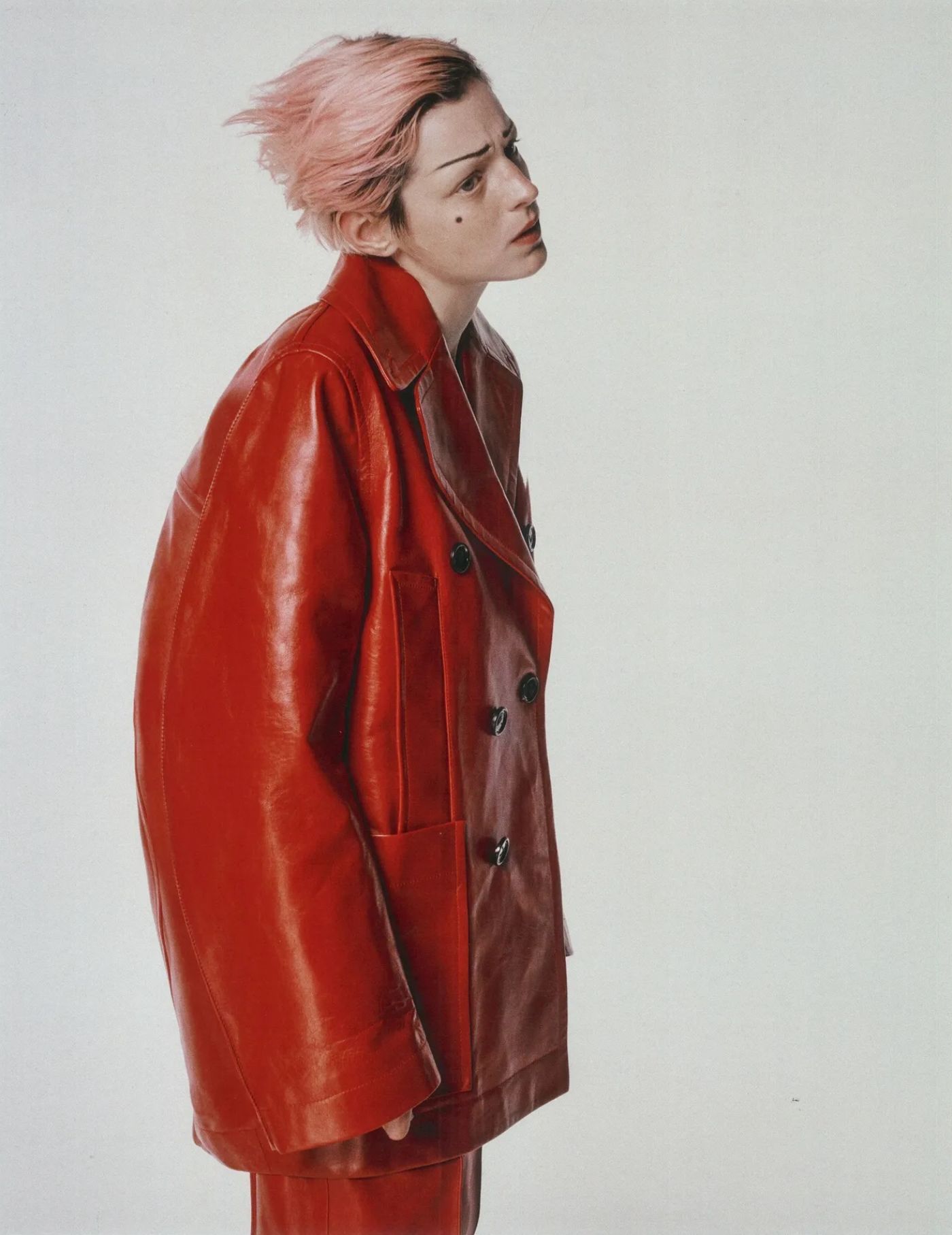 Emma Corrin in Bottega Veneta Red Curved Shape Leather Coat by Emily Lipson for The Cut October 2022