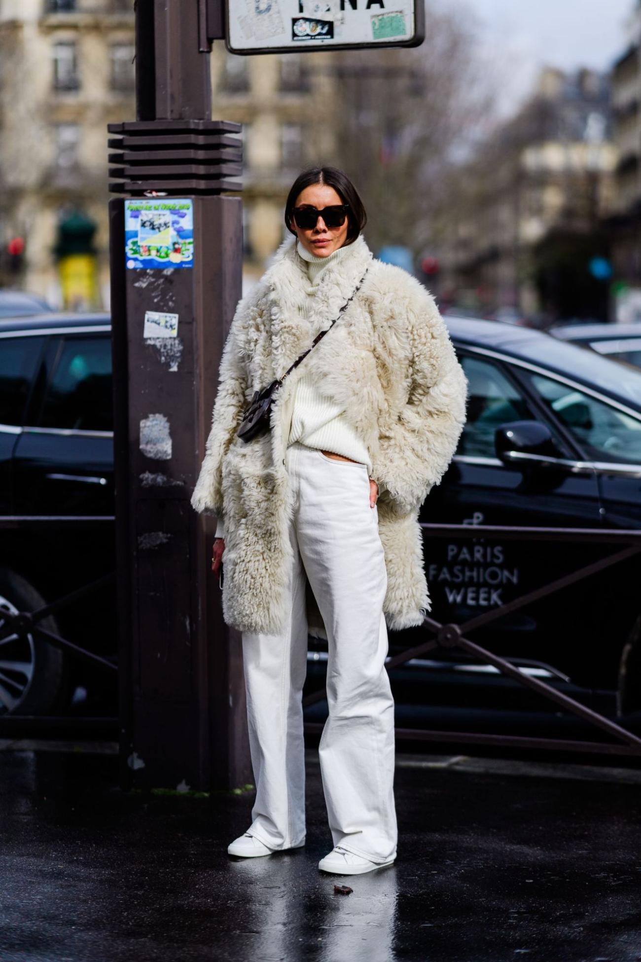 Julie Pelipas wears White Wide-Leg Denim, White Faux Fur Coat, Ribbed Turtleneck Sweater and White Trainers