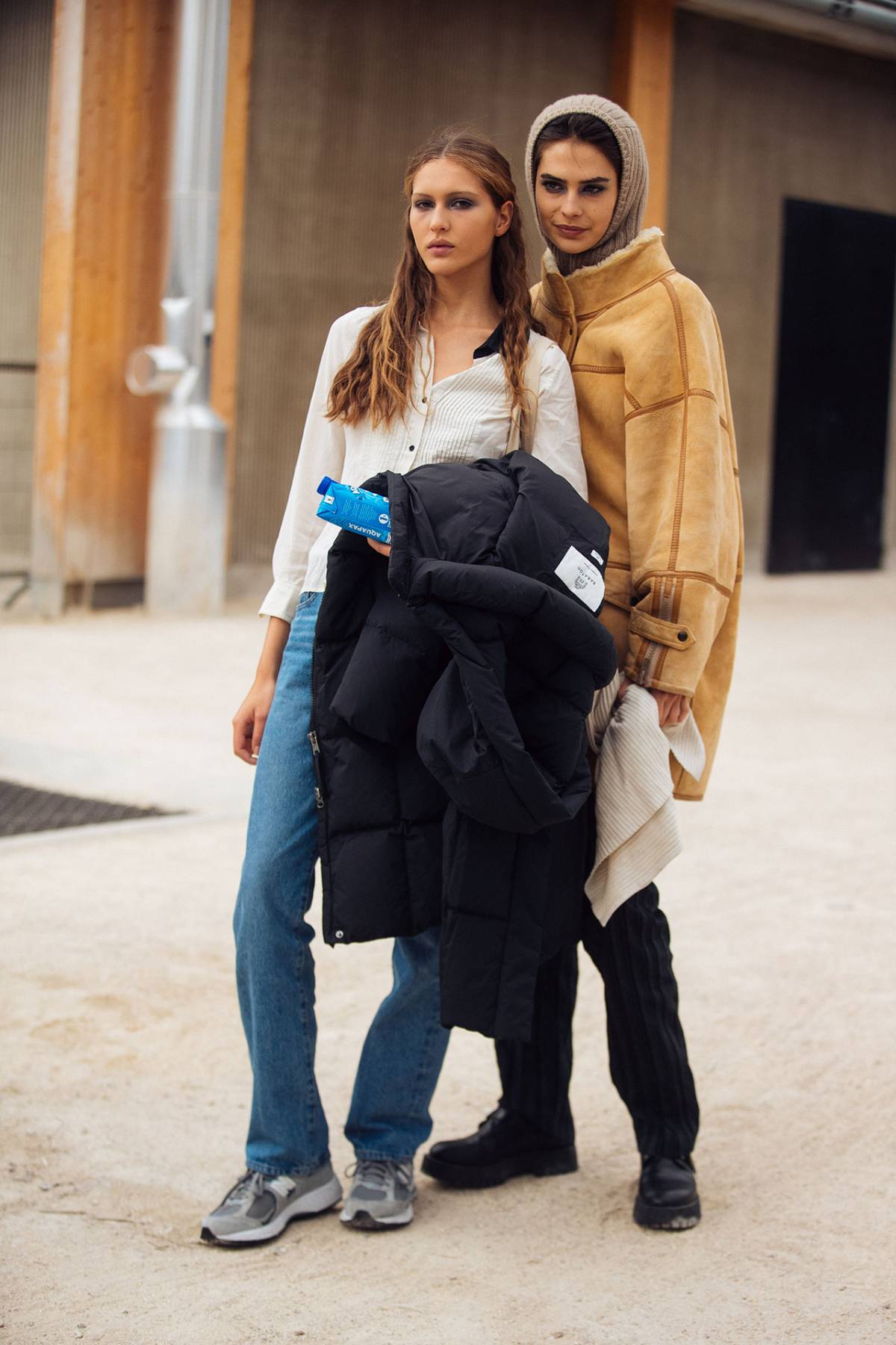 Angelina Kendall in New Balance Gray 2002R Sneakers with Evie Ashby in Shearling Jacket and Black Chunky Boots at Paris Fashion Week Fall-Winter 2023