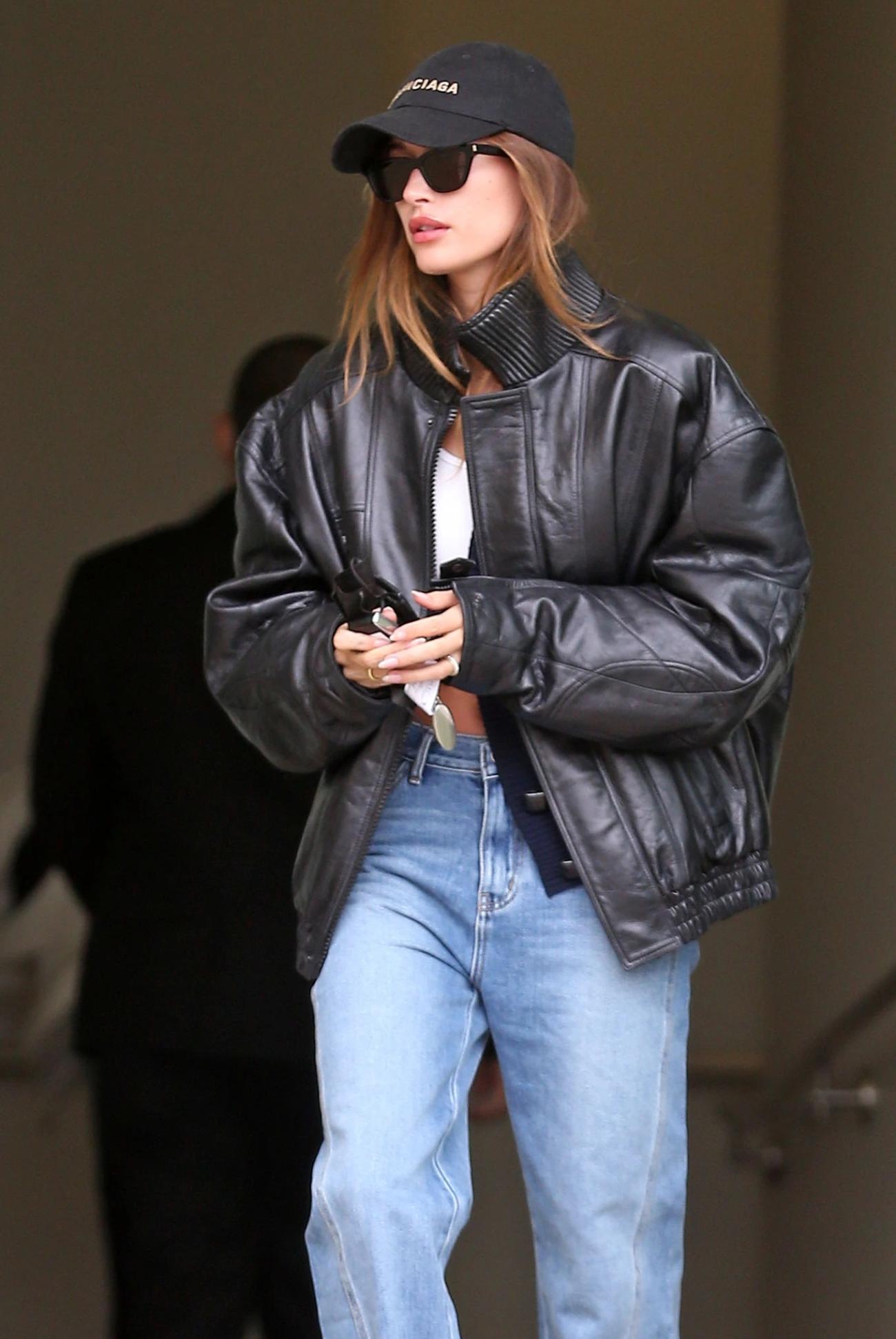 Celebrity Style Leather Boxy Moto Jacket, Baggy Jeans, White Crop Top, Balenciaga Black Logo-embroidered cotton-twill cap Outfit