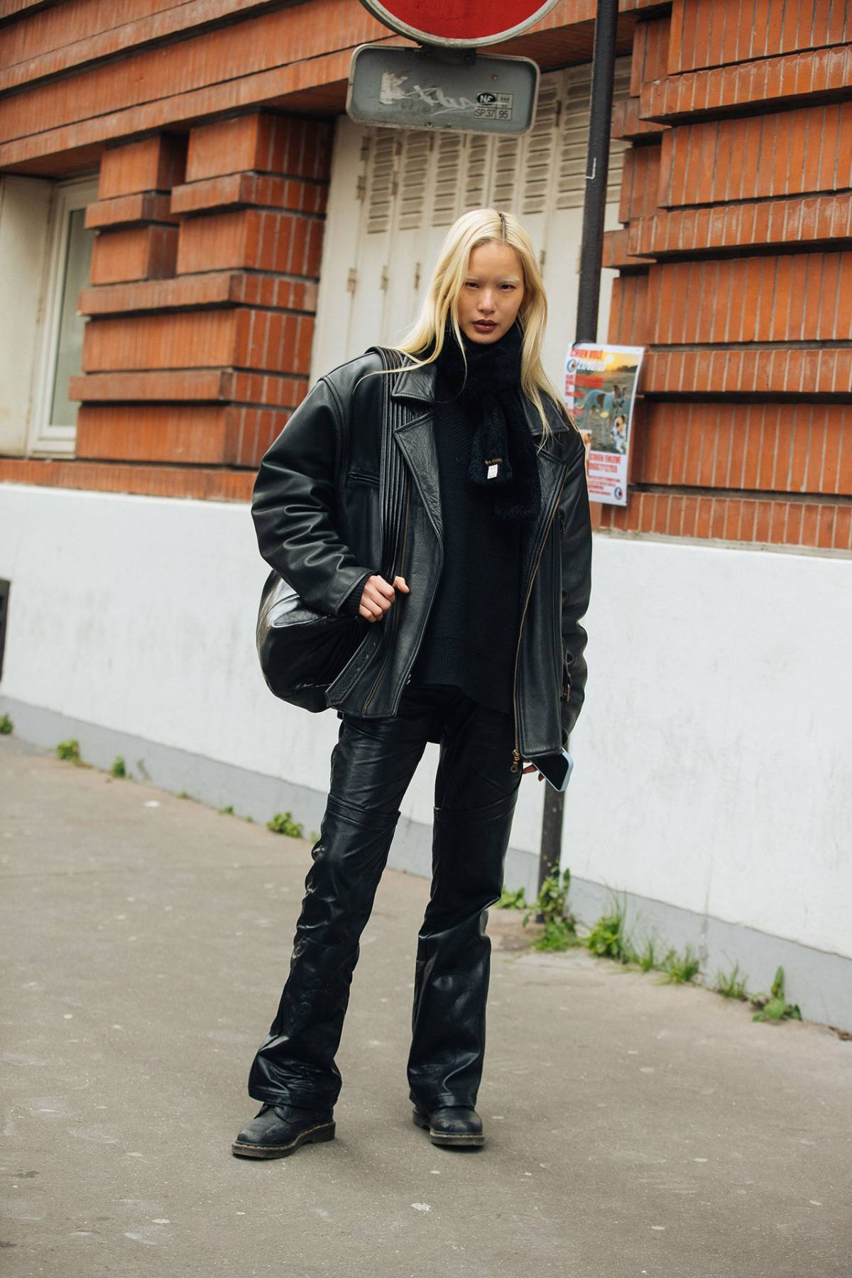 U Seng I wears Boxy Leather Jacket with Black Leather Pants and Dr. Martens Shoes at Paris Fashion Week Fall-Winter 2023