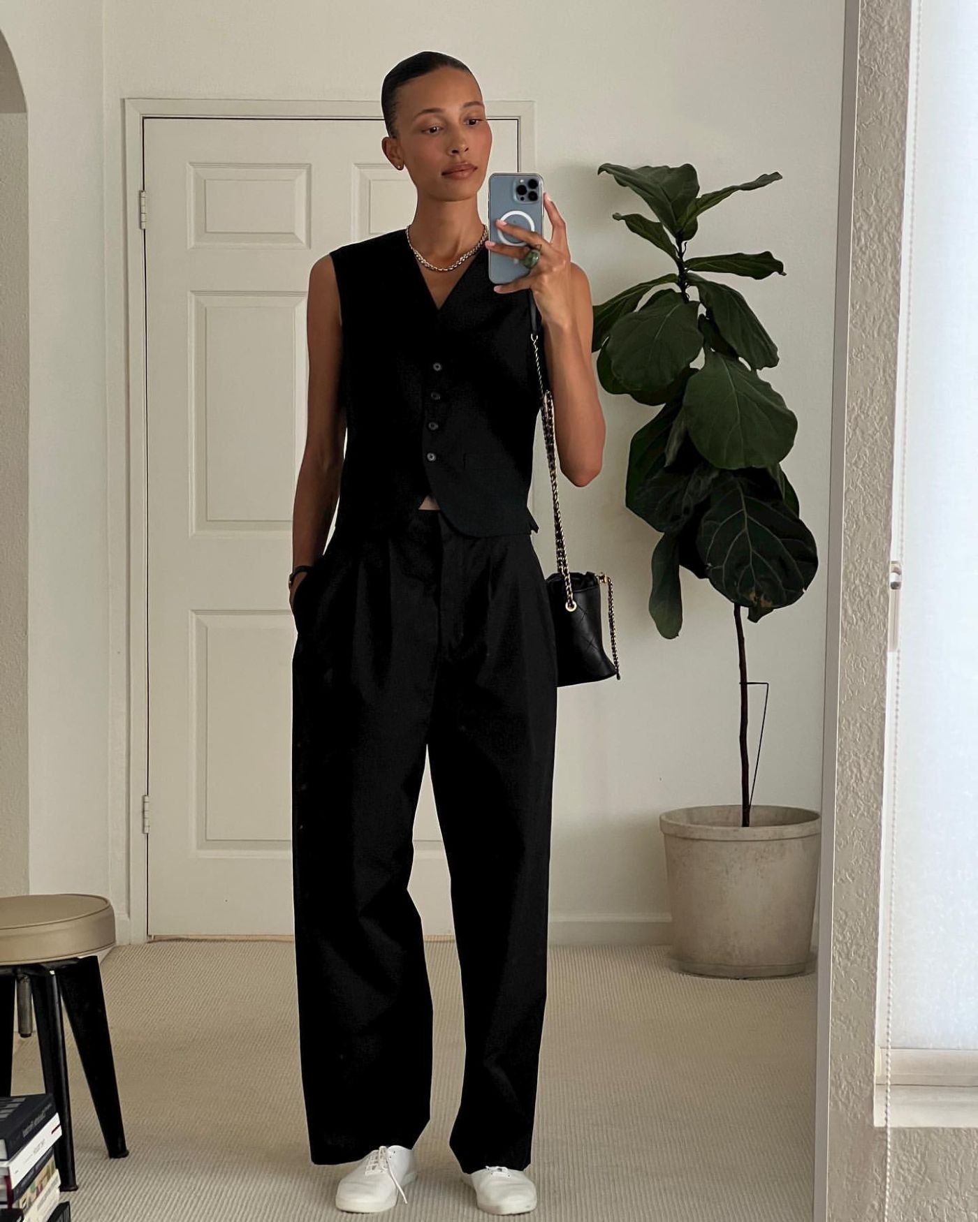 TyLynn Nguyen in The Row Matching Black Vest and Trousers, The Row White Sam Sneakers, Chanel Bag