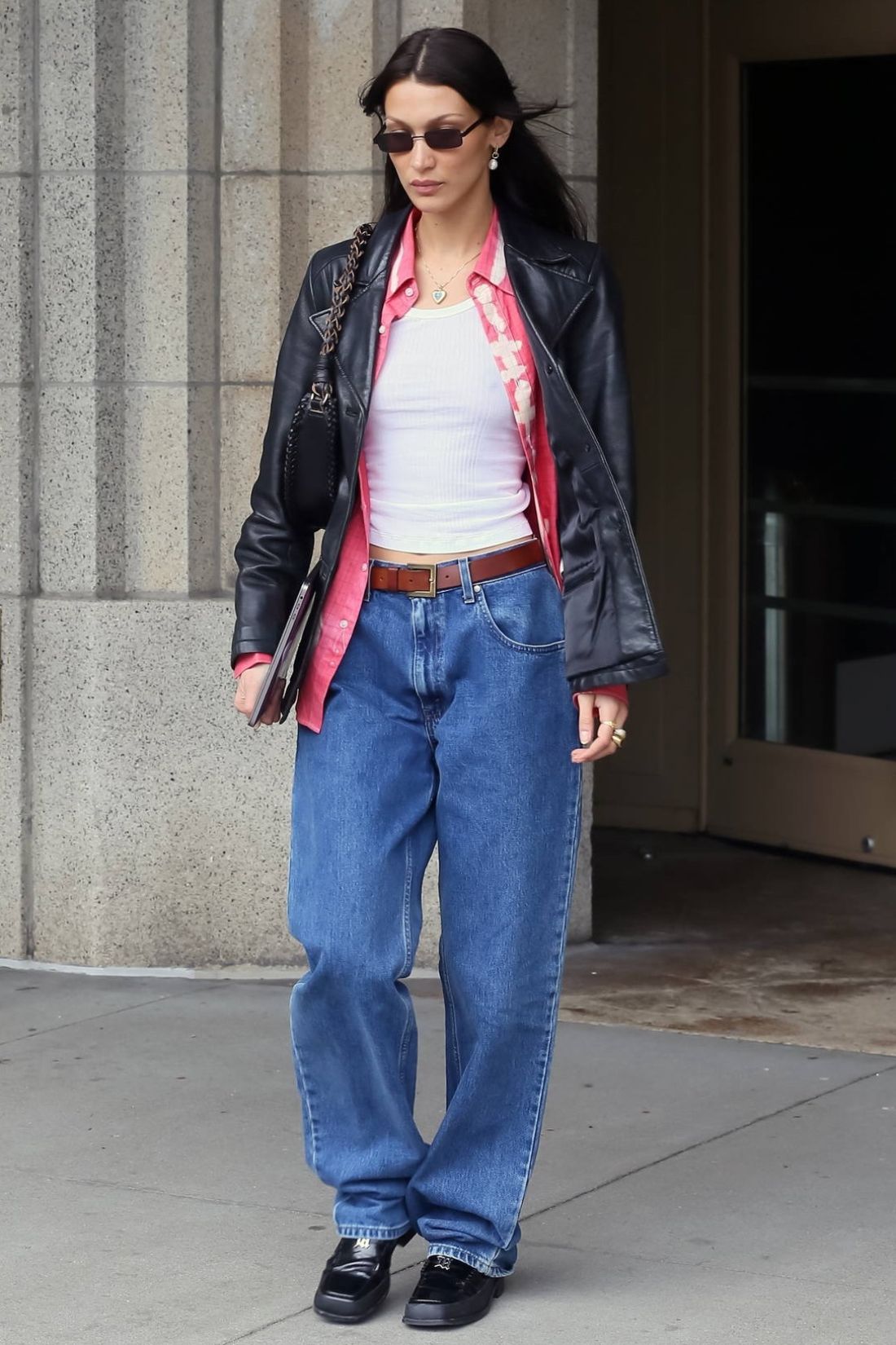Bella Hadid in Vintage Leather Jacket, White Tank Top, Oversized Blue Jeans, Loafers 90s-Inspired Outfit