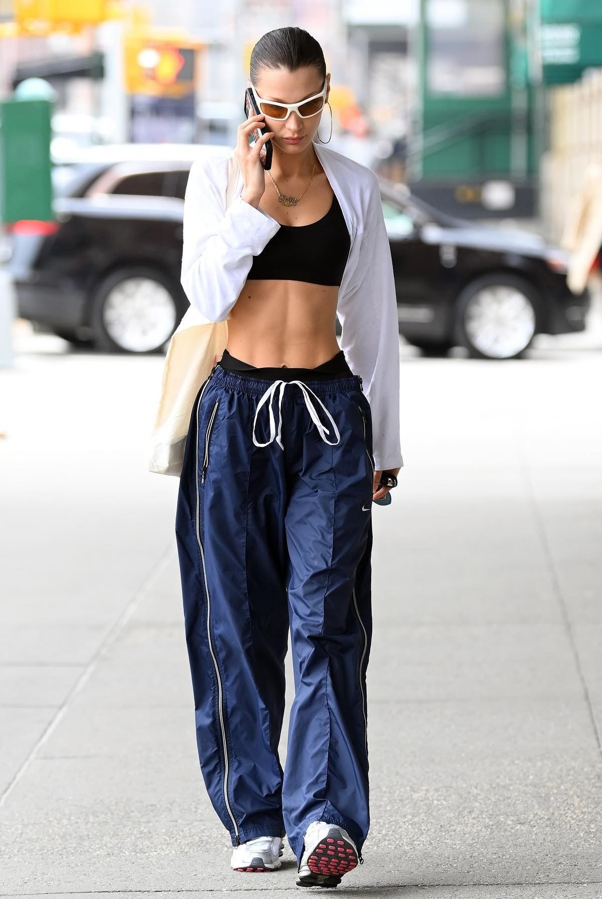 Bella Hadid wears Nike Track Pants, The M Jewelers Necklace, Lexxola Sunglasses Y2K Outfit