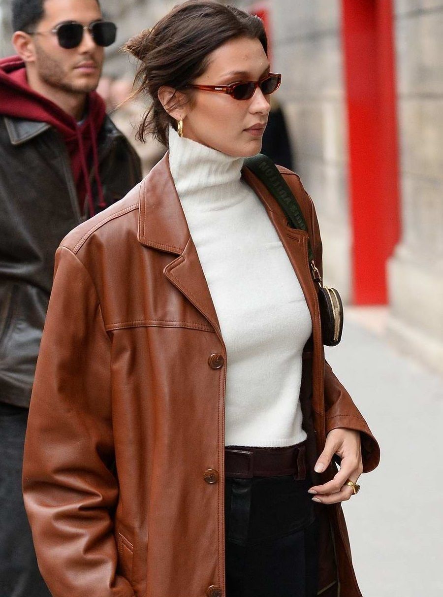 90s Outfit Bella Hadid wears Cognac Brown Leather Jacket, White Turtleneck, Black Pants, Louis Vuitton Shoulder Bag
