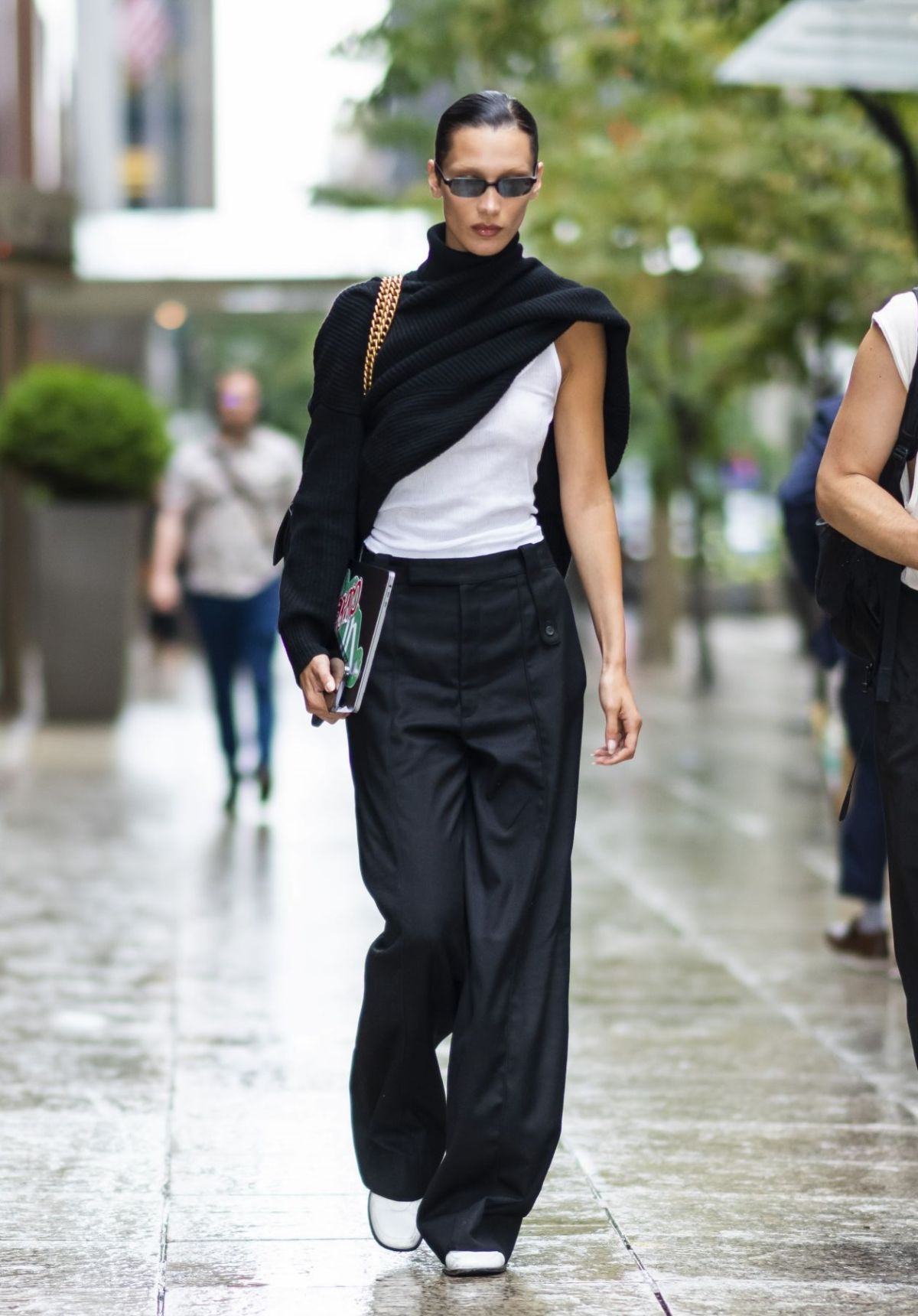 Bella Hadid wears White Tank Top, Black Sweater and Black Wide-Leg Pants Minimal Outfit