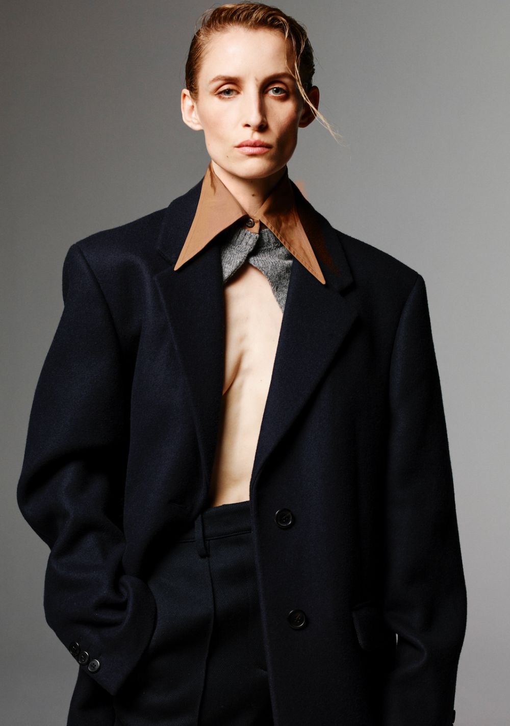 Gem Refoufi by Anthony Seklaoui for Luncheon Magazine Fall-Winter 2023, wearing Prada Navy Wool Coat with a point collar and grey knitted panel
